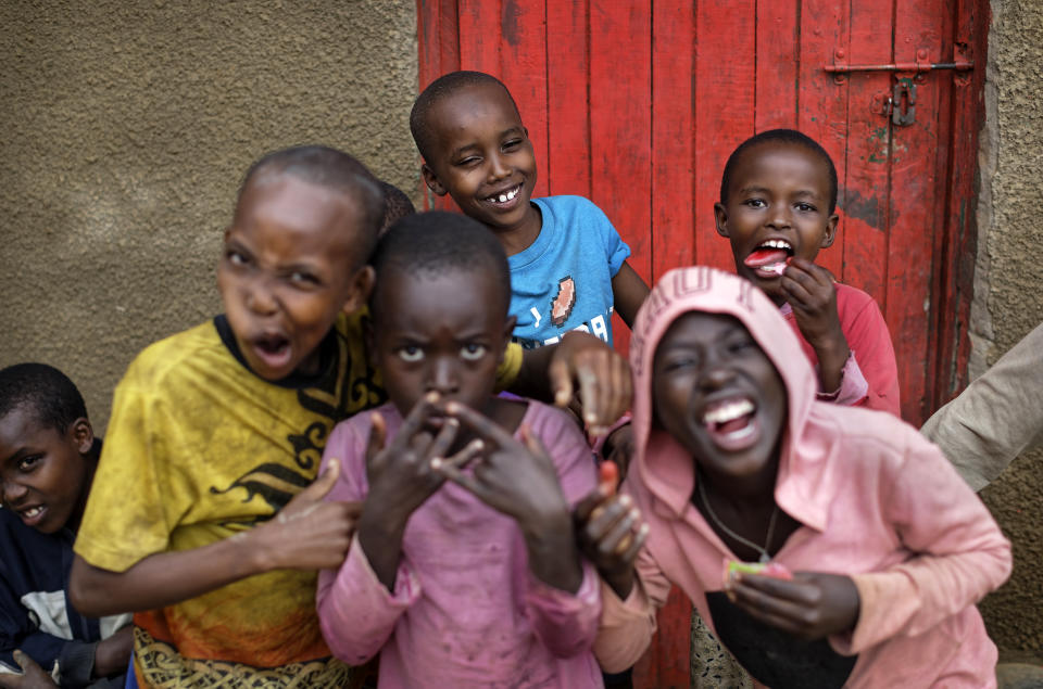 In this photo taken Thursday, April 4, 2019, the children of genocide survivors and perpetrators joke around as they play together in the reconciliation village of Mbyo, near Nyamata, in Rwanda. Twenty-five years after the genocide the country has six "reconciliation villages" where convicted perpetrators who have been released from prison after publicly apologizing for their crimes live side by side with genocide survivors who have professed forgiveness. (AP Photo/Ben Curtis)