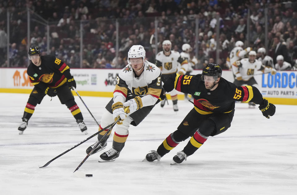 Vegas Golden Knights' Jack Eichel (9) skates with the puck past Vancouver Canucks' Guillaume Brisebois during the first period of an NHL hockey game Tuesday, March 21, 2023, in Vancouver, British Columbia. (Darryl Dyck/The Canadian Press via AP)