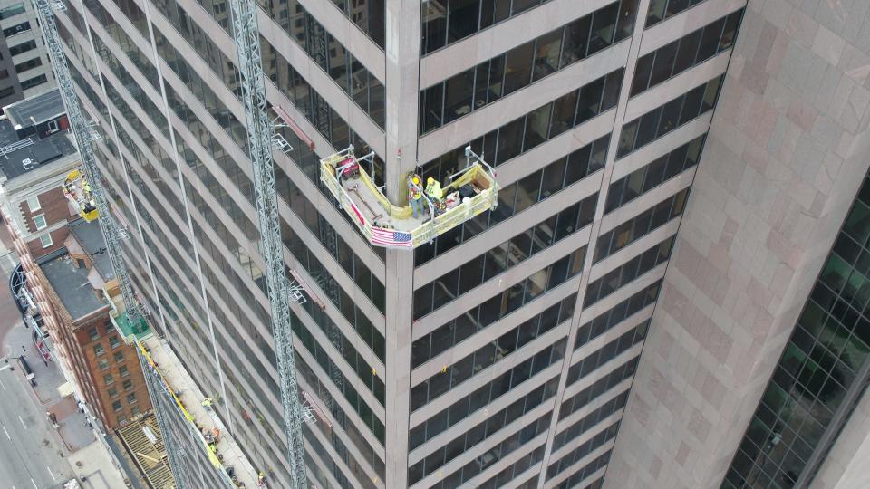 Workers used "swing stages" and "mast climbers" to scale the Rhodes Tower during renovation.