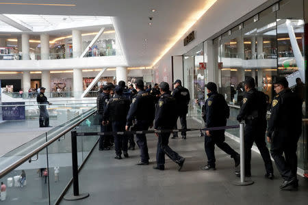 Police work outside a footwear shop after a man shot a woman in the abdomen there, before shooting himself in the head according to the police statement in Mexico City, Mexico March 19, 2018. REUTERS/Henry Romero