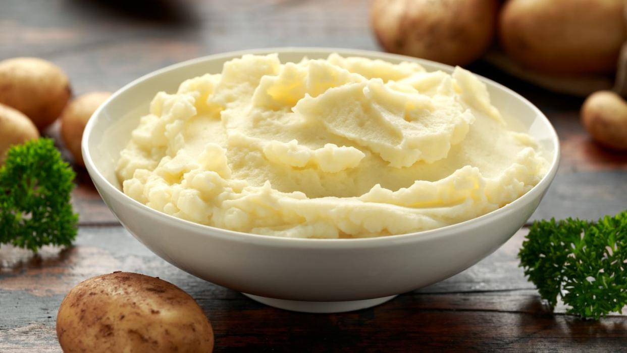 mashed potatoes in white bowl on wooden rustic table 
healthy food