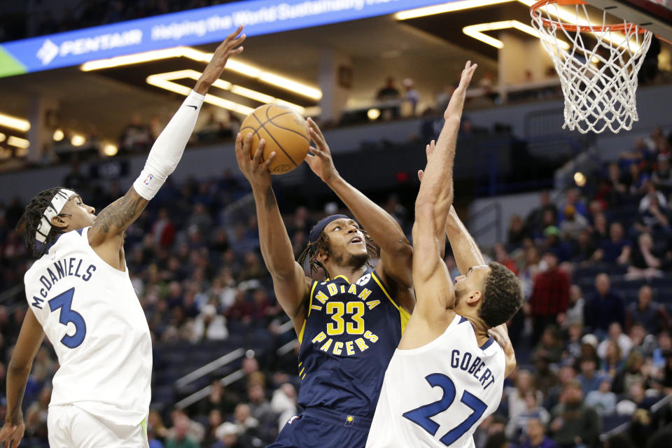 Indiana Pacers center Myles Turner (33) shoots on Minnesota Timberwolves center Rudy Gobert (27) and Timberwolves forward Jaden McDaniels (3) in the third quarter of an NBA basketball game, Wednesday, Dec. 7, 2022, in Minneapolis. (AP Photo/Andy Clayton-King)