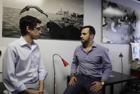 Raul Moas (L) and Felice Gorordo speak in their office in Miami Beach, Florida, December 19, 2014. REUTERS/Javier Galeano