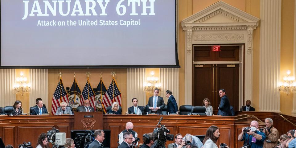 Several people congregate in the hearing room of the US Capitol.