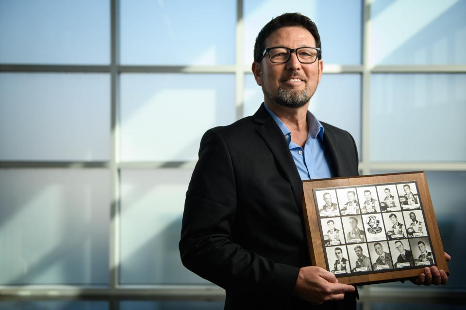 Kenneth Wasley holds a photo of the members of the Golden Knights team who died along with Wasley's father in a plane crash in Chatham County in 1973. His father is pictured in the bottom left corner of the photo. Wasley is founder of the group, Children of Fallen Heroes, and is working to create a center in Moore County for the children of fallen servicemembers and first responders.