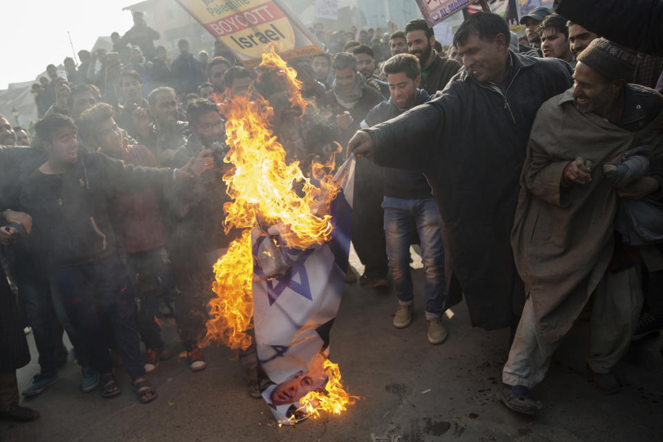 <p>Kashmiri Muslim men burn Israeli and U.S. flags during a protest against President Donald Trump’s decision to recognize Jerusalem as Israel’s capital in Budgam, southwest of Srinagar, Indian controlled Kashmir, Friday, Dec. 8, 2017.. (Photo: Dar Yasin/AP) </p>