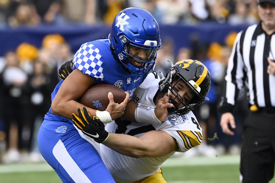 Kentucky quarterback Destin Wade, left, is brought down by Iowa linebacker Seth Benson (44) during the first half of the Music City Bowl NCAA college football game Saturday, Dec. 31, 2022, in Nashville, Tenn. (AP Photo/Mark Zaleski)