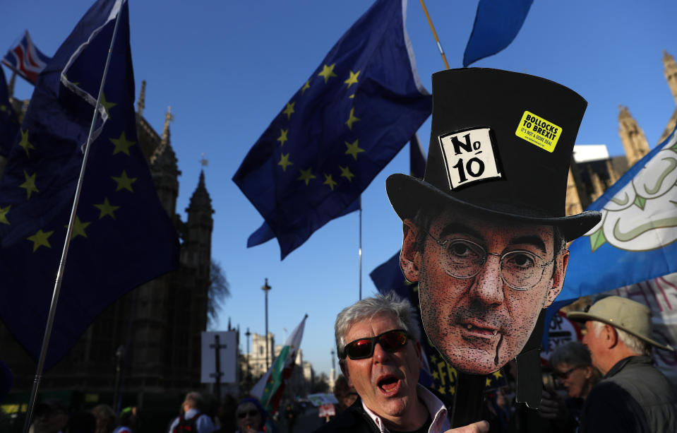 A remain in the European Union supporter holds up a placard showing the face of a prominent British lawmaker and leave the EU supporter Jacob Rees-Mogg, during a demonstration outside the Palace of Westminster in London, Wednesday, Feb. 27, 2019. British Prime Minister Theresa May says she will give British lawmakers a choice of approving her divorce agreement, leaving the EU March 29 without a deal or asking to delay Brexit by up to three months. (AP Photo/Alastair Grant)