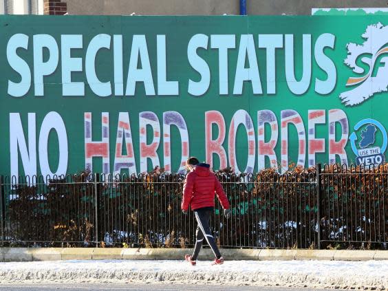 A pedestrian walks past a billboard in west Belfast (AFP/Getty)