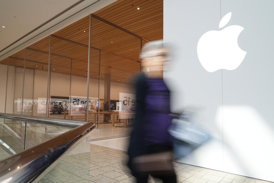 A person walks by an Apple store Oct. 20, 2023, in Denver. Major corporations in water-guzzling industries such as apparel, food and beverage, and tech want to be better stewards of the freshwater resources they use. Tech companies like Amazon and Apple need large amounts of water to cool the computers in their sprawling data centers. (AP Photo/Brittany Peterson)