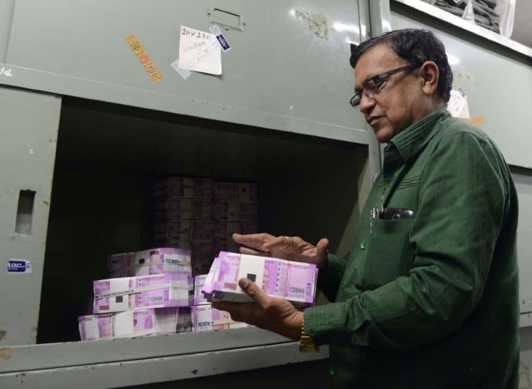 A bank employee in Ahmedabad, western India checks stacks of new 2000 rupee notes on November 11, 2016