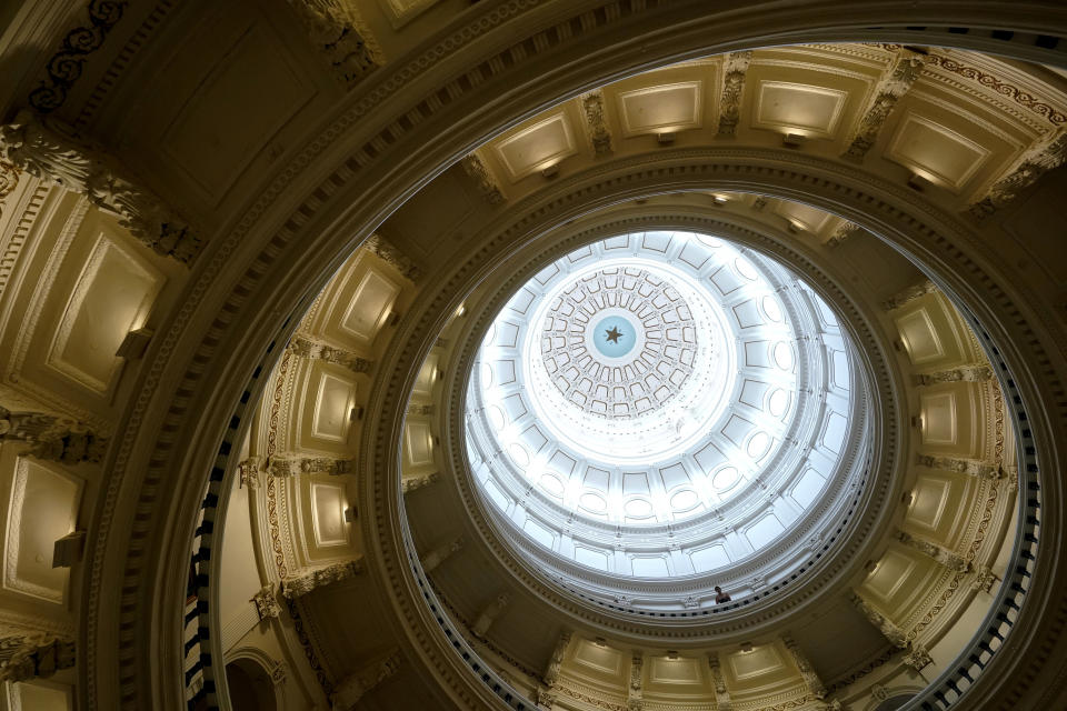 A visitor leans over a railing in the rotunda at the State Capitol, Tuesday, June 1, 2021, in Austin, Texas. The Texas Legislature closed out its regular session Monday, but are expected to return for a special session after Texas Democrats blocked one of the nation's most restrictive new voting laws with a walkout. (AP Photo/Eric Gay)