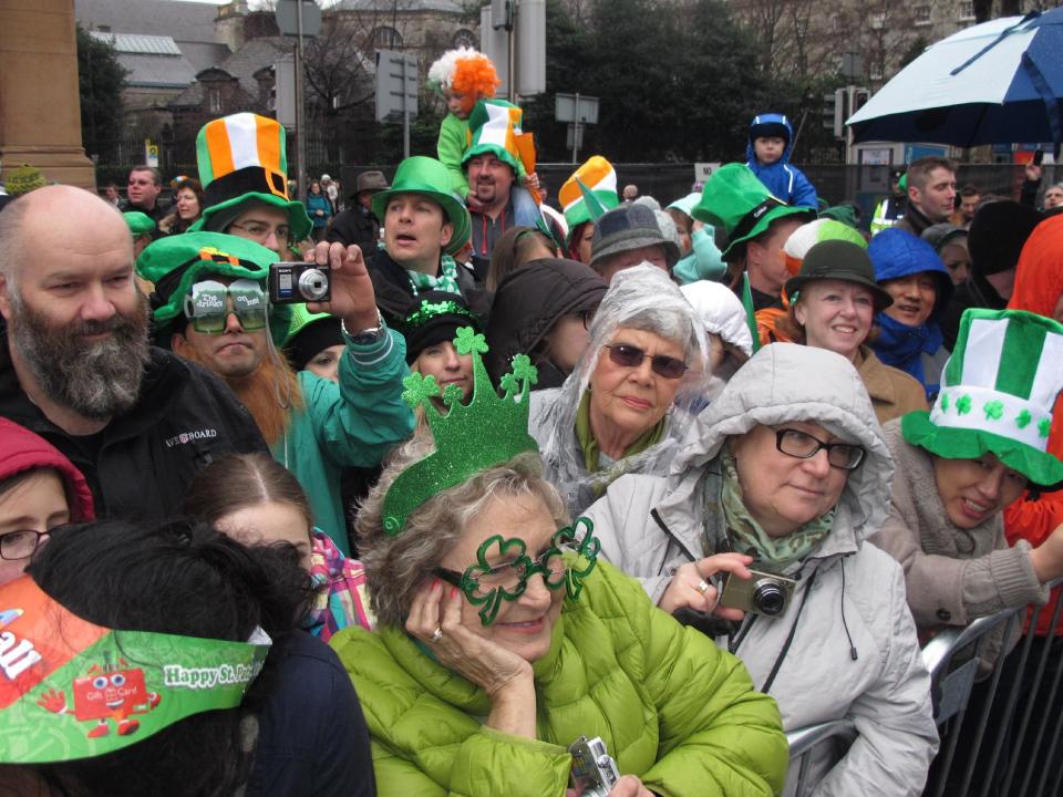 Spectators watch the St. Patrick's Day parade in Dublin, Sunday, March 17, 2013. Never mind the fickle Irish weather - a chilly, damp Dublin celebrated St. Patrick's Day with artistic flair Sunday as the focal point for a weekend of Irish celebrations worldwide. (AP Photo/Shawn Pogatchnik)