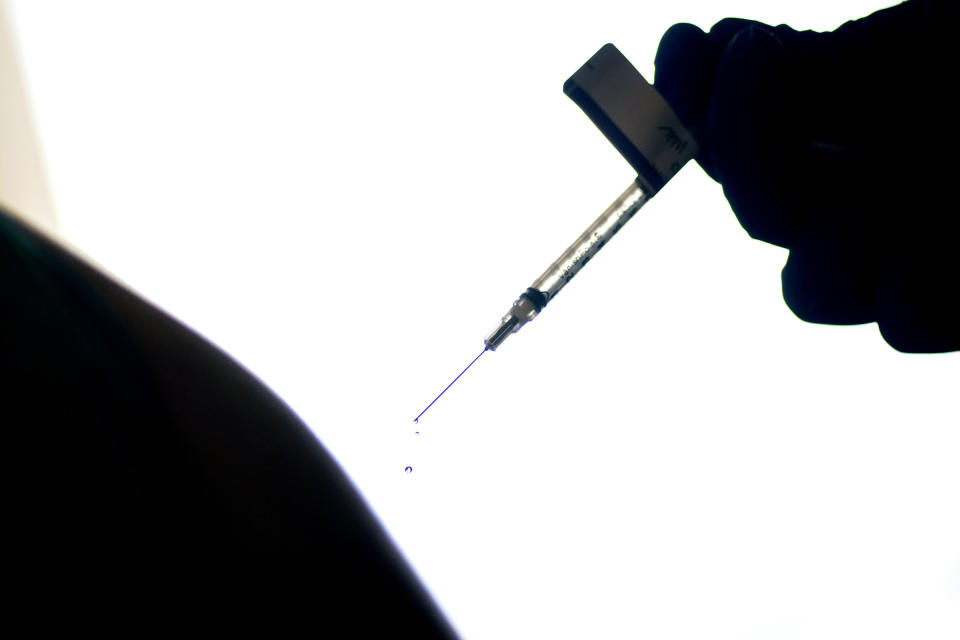 FILE - In this Dec. 15, 2020, file photo, a droplet falls from a syringe after a health care worker was injected with the Pfizer COVID-19 vaccine at a hospital in Providence, R.I. An untold number of Americans have managed to get COVID-19 booster shots even though the U.S. government hasn't approved them. They're doing so by taking advantage of the nation’s vaccine surplus and loose tracking of those who have been fully vaccinated. (AP Photo/David Goldman, File)