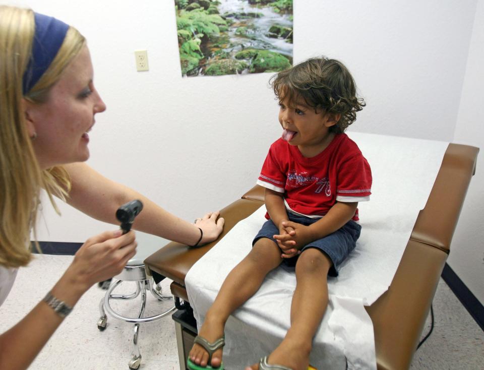 David Evangelista sticks his tongue out for nurse practitioner Emily Schlechte during his appointment in 2008 at the Lone Star Circle of Care's Round Rock Health Clinic. The state of Texas has to verify that 2.7 million children and women still qualify for Medicaid after continuous enrollment ended in March.