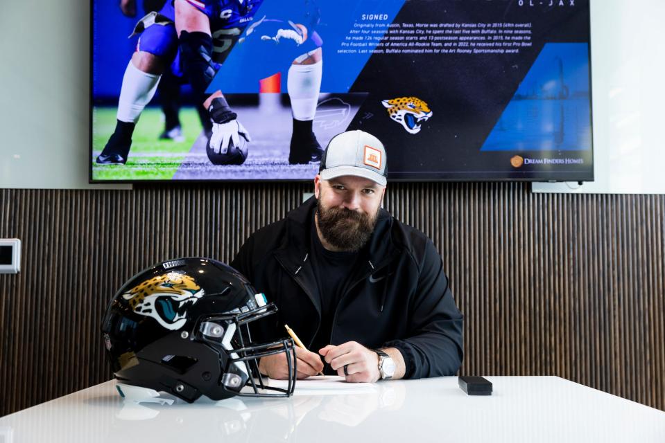 Jacksonville Jaguars center Mitch Morse signs his reported two-year contract with the team on Wednesday, March 13, 2024.