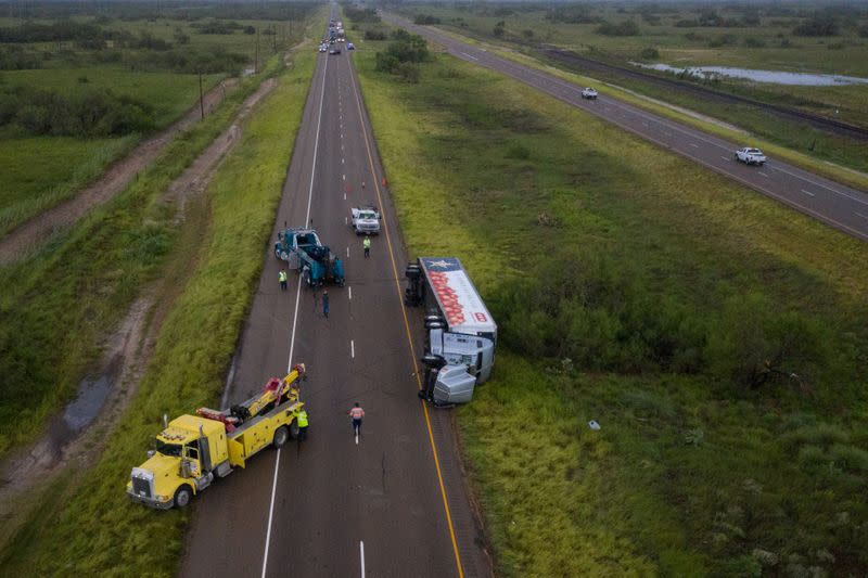 Tow trucks surround overturned truck in aftermath of Hurricane Hanna in Sarita, Texas