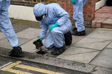 Forensic investigators examine the pavement and carriageway on Chalgrove Road, where a teenage girl was murdered, in Tottenham, Britain, April 3, 2018. REUTERS/Toby Melville