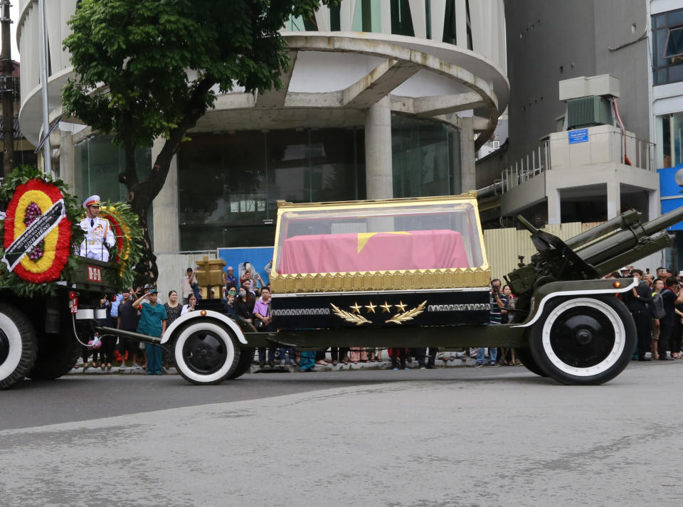 National flag-draped coffin of late President Tran Dai Quang on truck-drawn artillery carriage passes by in Hanoi, Vietnam, Thursday, Sept. 27, 2018. Thousands of people line streets in capital Hanoi to pay their last respects to the late president who died last week of viral illness. (AP Photo/Tran Van Minh)