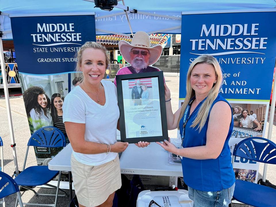 Michelle Boykin, right, Rackley Roofing's chief operating officer and alumna of MTSU, is honored Friday, June 24, at the Nashville Superspeedway by MTSU Daniels Center Director Hilary Miller for her company's support of veterans. They were attending the Rackley Roofing 200 NASCAR Camping World Truck Series event at the Nashville Superspeedway in Gladeville, Tenn.