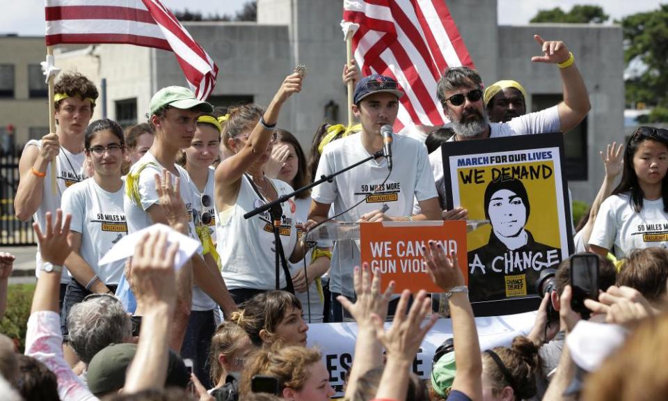 David Hogg, center, a survivor of the school shooting at Marjory Stoneman Douglas high school, in Parkland, Florida, addresses a rally in front of the headquarters of gun manufacturer Smith & Wesson in Springfield, Mass on 26 August.