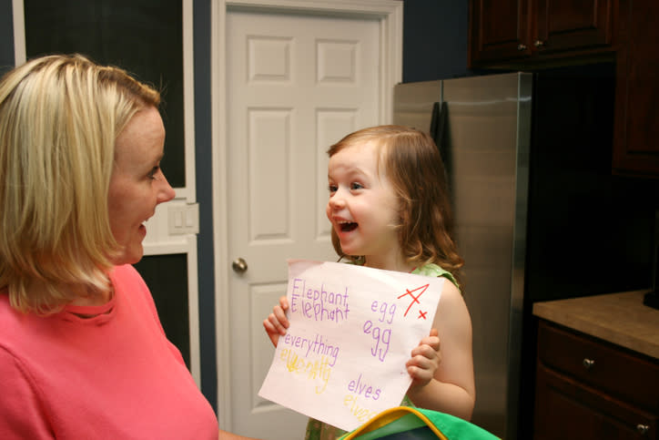 A kid showing their parents their spelling test