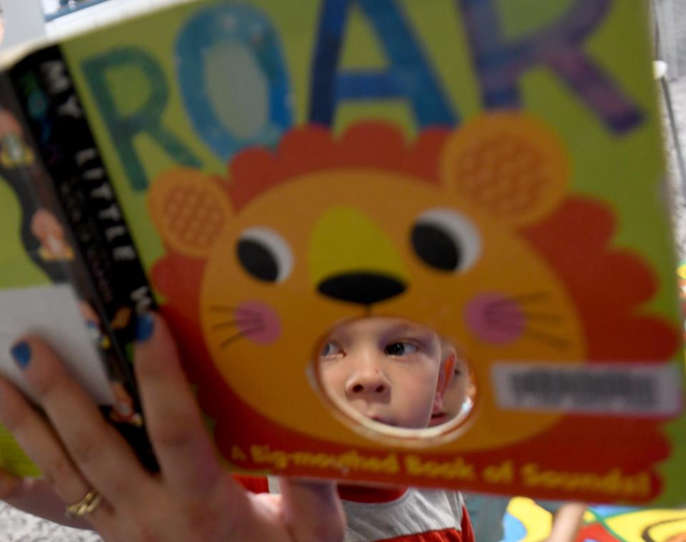 Ramsey Gemmell, 3, of Perry Township, keeps his eye on the book during summer story time at the Massillon Public Library.