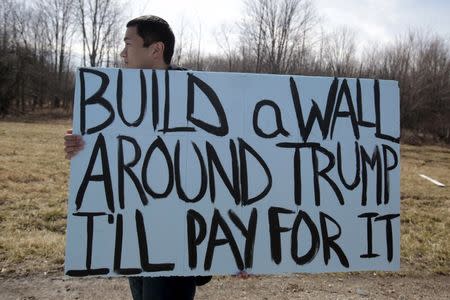 An anti-Trump protester holds his protest sign outside a rally for Republican U.S. presidential candidate Donald Trump in Cleveland, Ohio, March 12, 2016. REUTERS/Rebecca Cook