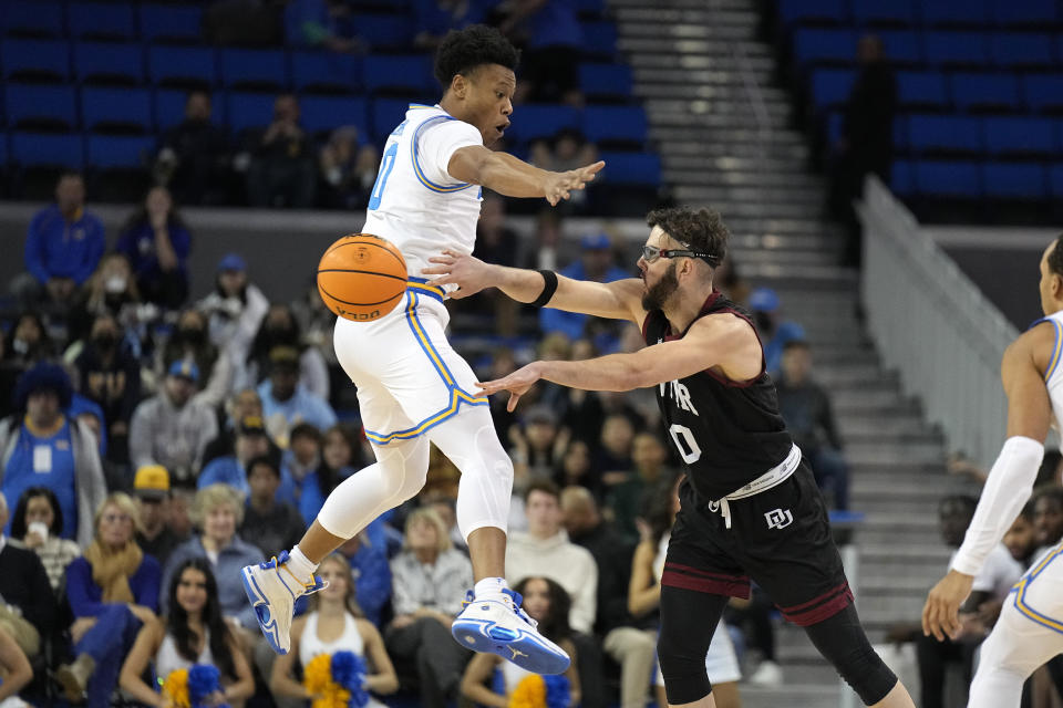 Denver guard Marko Lukic, right, passes as UCLA guard Jaylen Clark defends during the first half of an NCAA college basketball game Saturday, Dec. 10, 2022, in Los Angeles. (AP Photo/Mark J. Terrill)