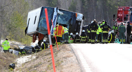 Rescue workers are seen at the site where a bus carrying school children and adults rolled over on a road close to the town of Sveg, in northern Sweden April 2, 2017. TT News Agency/Nisse Schmidt/via REUTERS