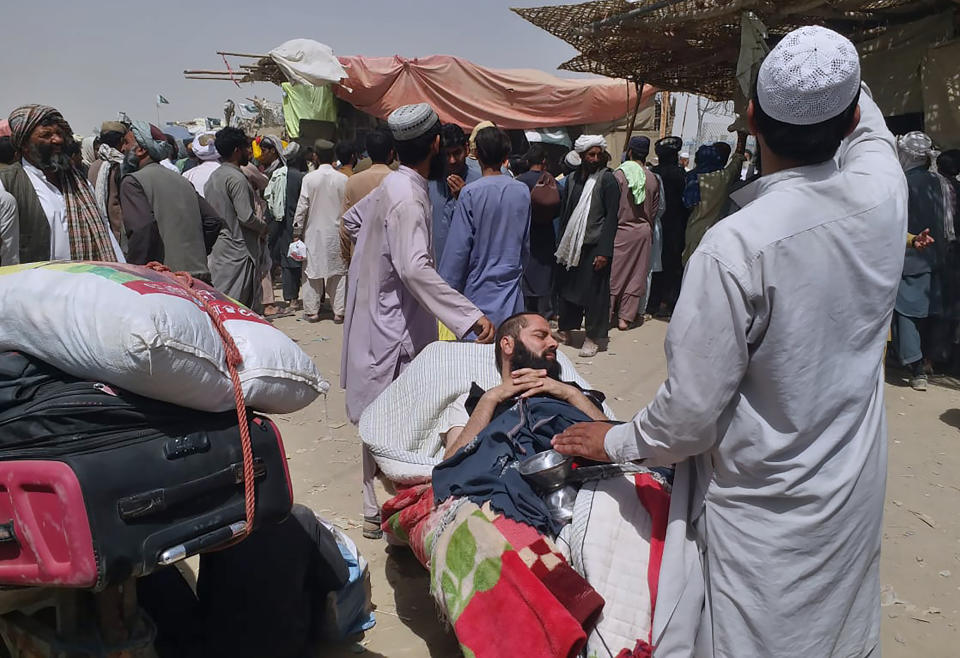 FILE - A porter pushes a wheelbarrow carrying a sick Afghan national as he and his relatives enter Pakistan through a border crossing point in Chaman, Pakistan, Monday, Aug. 23, 2021. Pakistan is rallying Muslim countries to help Afghanistan stave off an economic and humanitarian disaster while also cajoling the neighboring country's new Taliban rulers into concessions to soften their image abroad. (AP Photo/Jafar Khan, File)