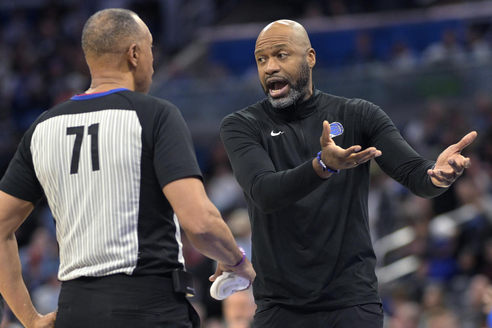 Orlando Magic head coach Jamahl Mosley, right, argues a point with official Rodney Mott (71) during a timeout in the first half of an NBA basketball game against the Atlanta Hawks, Sunday, Jan. 7, 2024, in Orlando, Fla. (AP Photo/Phelan M. Ebenhack)