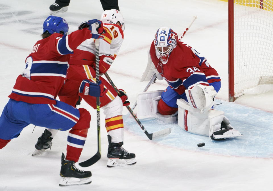 Montreal Canadiens goaltender Jake Allen makes a save on Calgary Flames' Matthew Tkachuk as Canadiens' Ben Chiarot defends during the first period of an NHL hockey game Friday, April 16, 2021, in Montreal. (Paul Chiasson/The Canadian Press via AP)