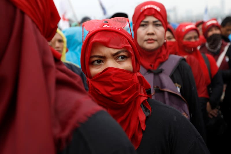 A labourer looks on as she takes part in a protest outside Indonesia's parliament building in Jakarta