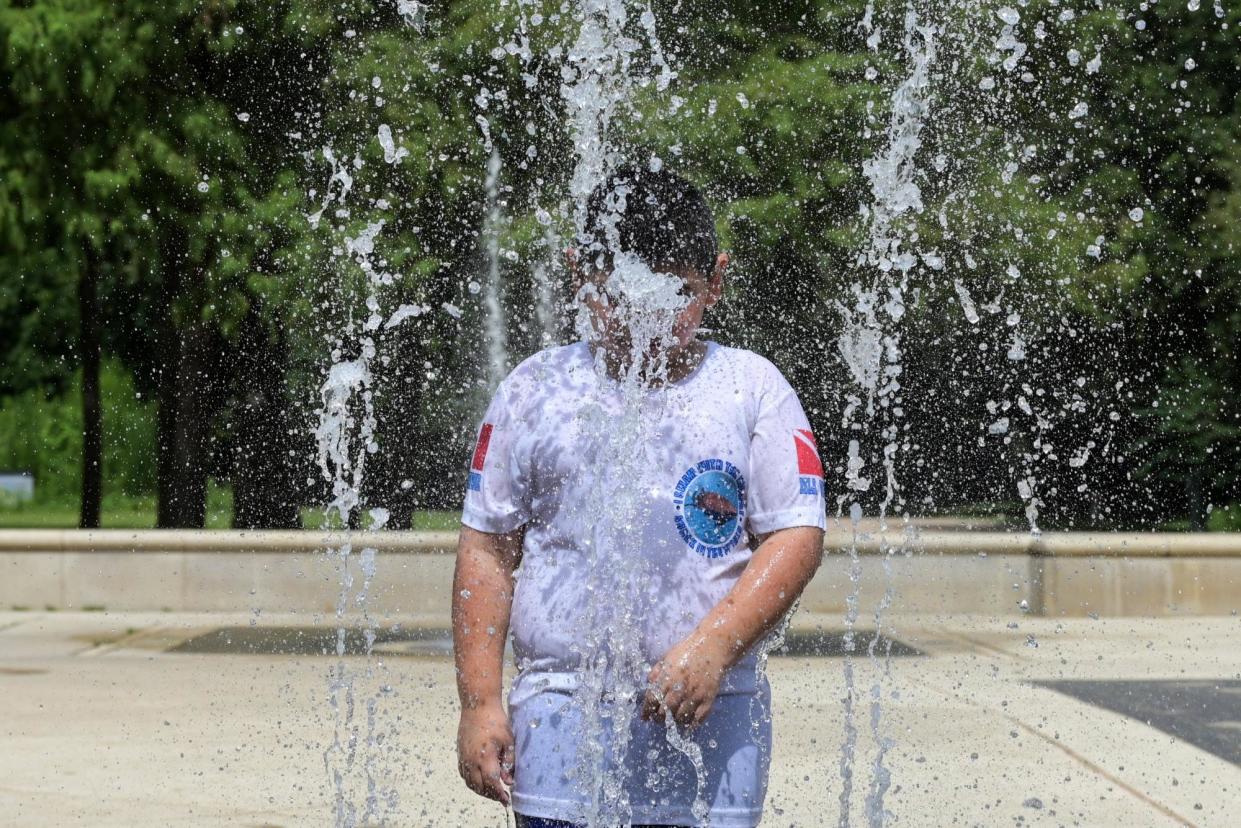 <span>A child cools off in a fountain in Houston, Texas, on 3 July 2024.</span><span>Photograph: Juan Mabromata/AFP via Getty Images</span>