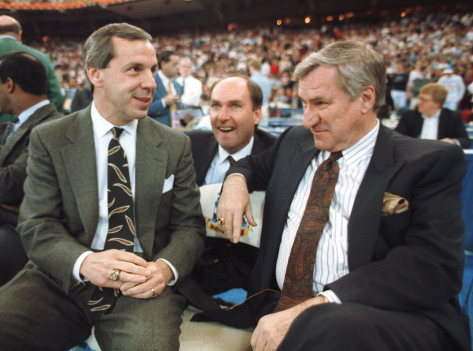 In this March 30, 1991 file photo, Kansas coach Roy Williams, left, and North Carolina coach Dean Smith talk before the start of the first NCAA national semifinal in Indianapolis, Indiana. AP Photo/Bob Jordan