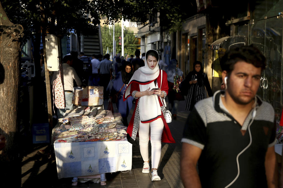 People make their way on a sidewalk in downtown Tehran, Iran, Monday, July 30, 2018. Iran's currency has dropped to a record low ahead of the imposition of renewed American sanctions, with many fearing prolonged economic suffering or possible civil unrest. (AP Photo/Ebrahim Noroozi)