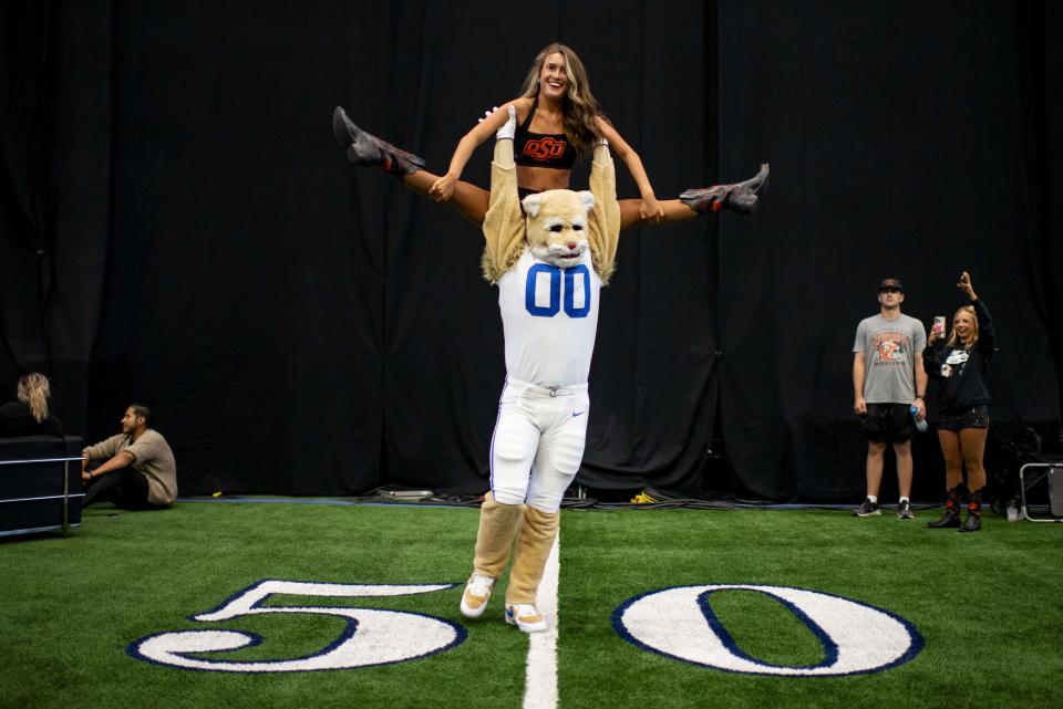 BYU mascot Cosmo the Cougar spins around with Oklahoma State cheerleader Macy Lane during Big 12 football media days in Arlington, Texas, Thursday, July 13, 2023. | Emil T. Lippe, Associated Press