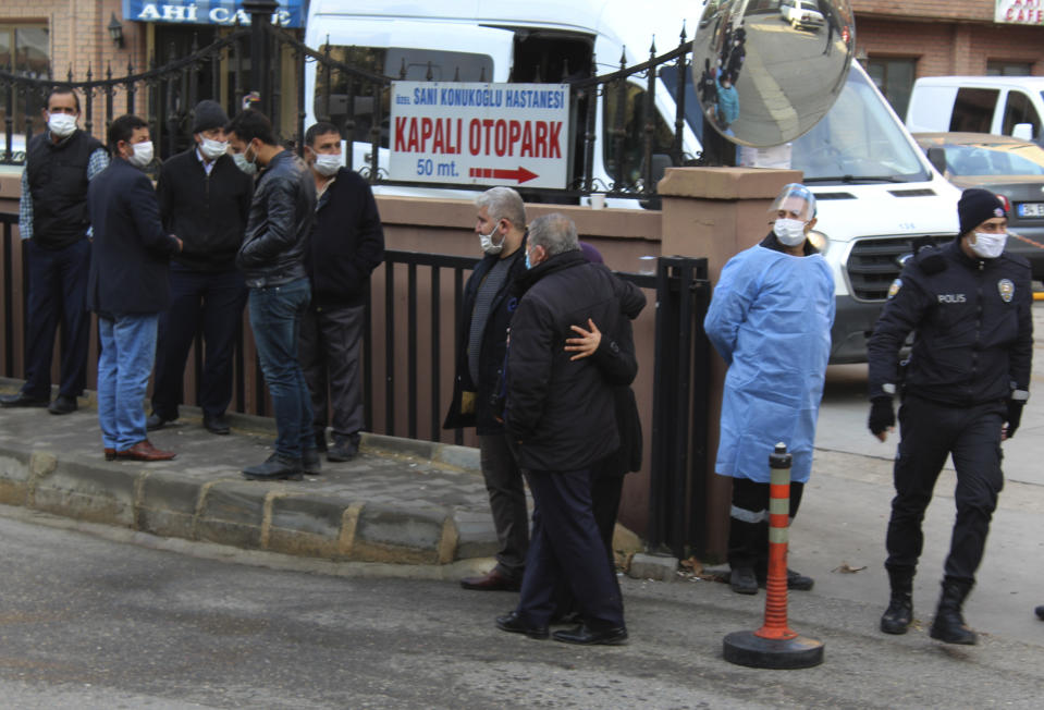 People, police and medics gather outside the privately-run Sanko University Hospital in Gaziantep, southeastern Turkey, Saturday, Dec. 19, 2020. A fire broke out Saturday at an intensive care unit treating COVID-19 patients in southern Turkey after an oxygen cylinder exploded, killing several people, state-run media reported. (IHA via AP)