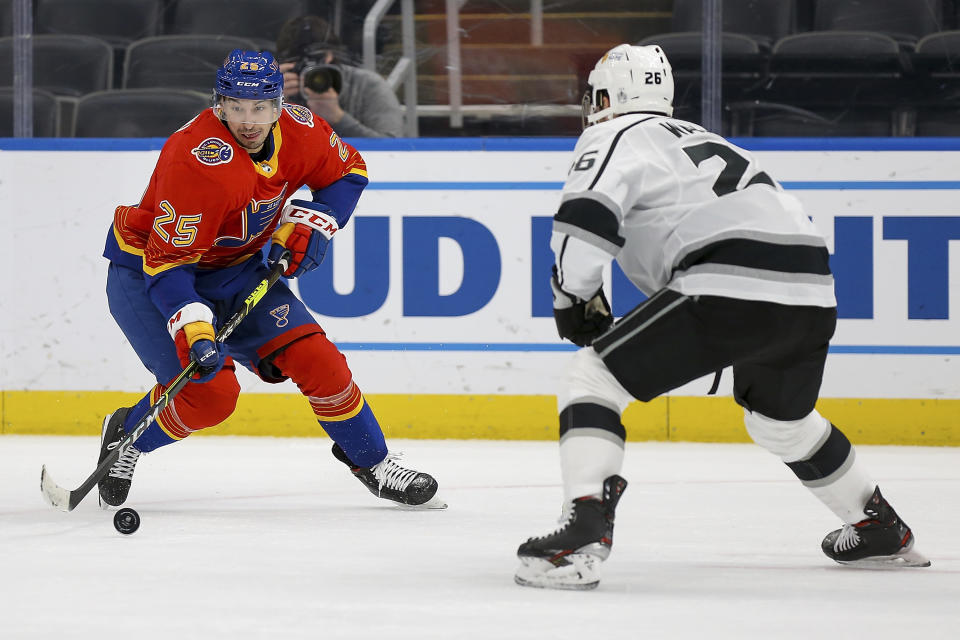 St. Louis Blues' Jordan Kyrou (25) handles the puck while under pressure from Los Angeles Kings Sean Walker (26) during the second period of an NHL hockey game Monday, Feb. 22, 2021, in St. Louis. (AP Photo/Scott Kane)