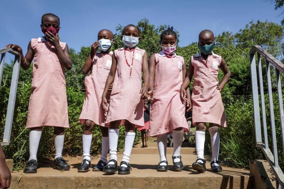 Pupils walk around the school compound during break time at Kitante Primary School in Kampala, Uganda Monday, Jan. 10, 2022. Uganda's schools reopened to students on Monday, ending the world's longest school disruption due to the COVID-19 pandemic. (AP Photo/Hajarah Nalwadda)