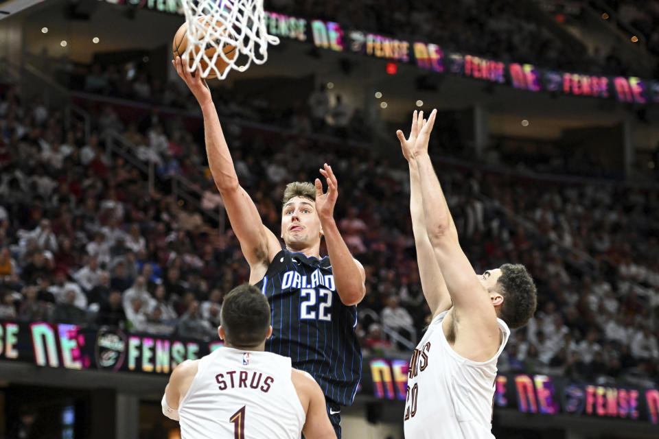 Orlando Magic's Franz Wagner (22) shoots over Cleveland Cavaliers' Max Strus (1) and Georges Niang (20) during the second half in Game 1 of an NBA basketball first-round playoff series, Saturday, April 20, 2024, in Cleveland. (AP Photo/Nick Cammett)