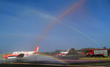 Water cannons spray coloured water on three units of Beechcraft TC90 aircraft from the Japan Ministry of Defense (JMOD) upon their arrival, during a transfer ceremony of the aircrafts to the Philippine Navy at the Naval Air Group (NAG) headquarters in Sangley Point, Cavite city, Philippines March 26, 2018. REUTERS/Romeo Ranoco