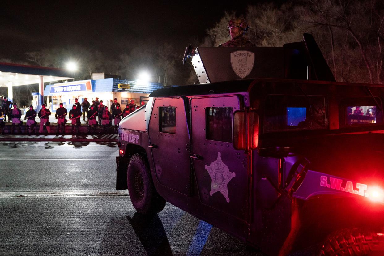 Authorities advance into a gas station after pursuing demonstrators for violating curfew and issuing orders to disperse during a protest against the police shooting of Daunte Wright, late Monday, April 12, 2021, in Brooklyn Center, Minn.