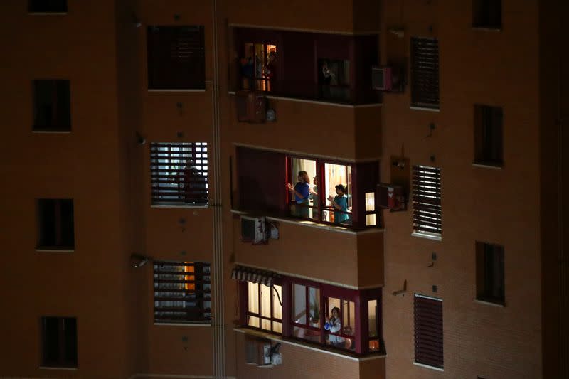 People applaud from their apartment windows as part of an event organized through social media to show gratitude to healthcare workers during the coronavirus outbreak, in Madrid