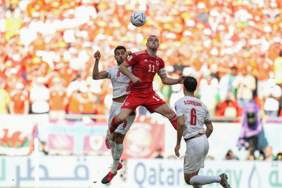 Iran's Morteza Pouraliganji, left, and Wales' Gareth Bale go for a header during the World Cup group B soccer match between Wales and Iran, at the Ahmad Bin Ali Stadium in Al Rayyan , Qatar, Friday, Nov. 25, 2022. (AP Photo/Francisco Seco)