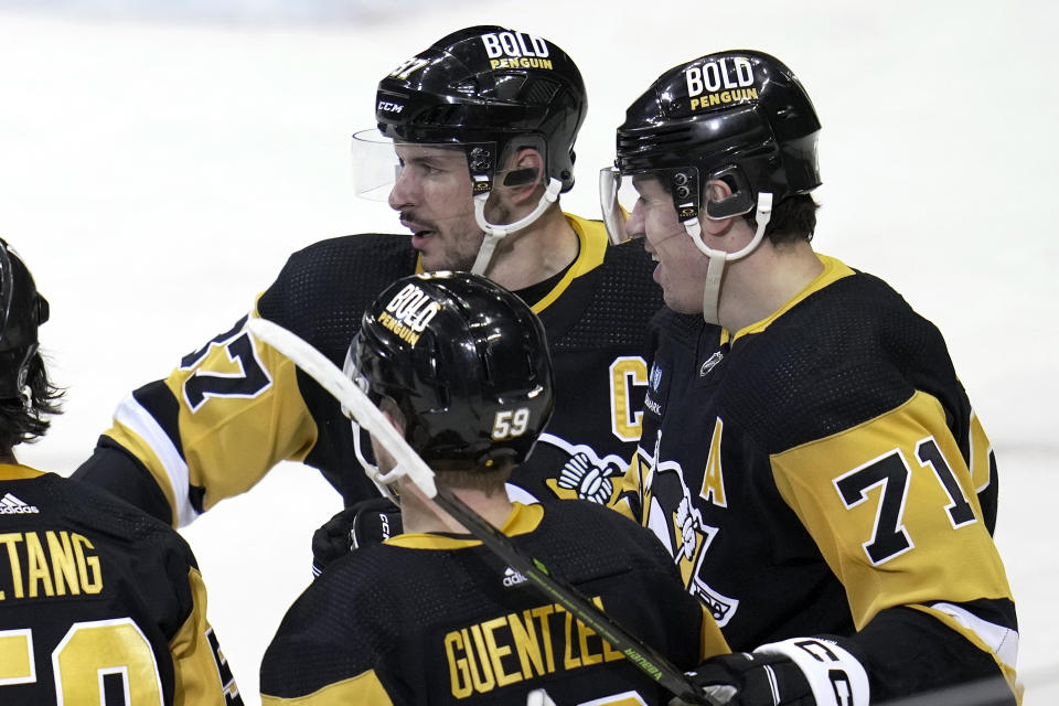 Pittsburgh Penguins' Evgeni Malkin (71) celebrates with Sidney Crosby, top center and Jake Guentzel (59) after scoring against the Montreal Canadiens during the first period of an NHL hockey game in Pittsburgh, Tuesday, March 14, 2023. (AP Photo/Gene J. Puskar)