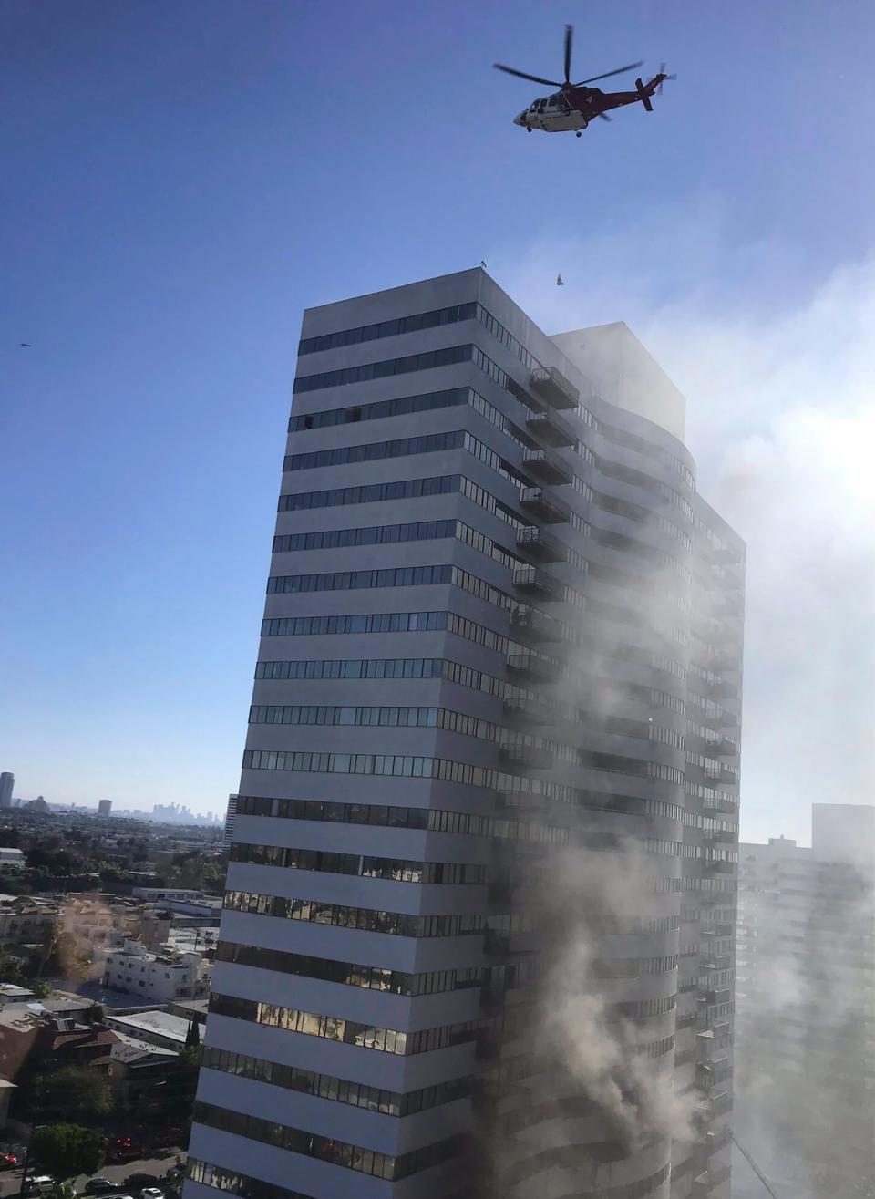 A helicopter flies over a residential building that was on fire in Los Angeles on Jan. 29, 2020.