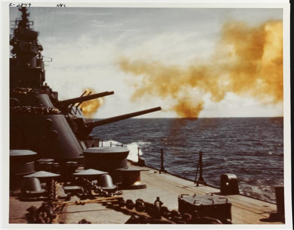 The USS Biloxi firing her 6 inch main battery guns during her shakedown cruise, October 1943. View looking after on the port side. National Archives.