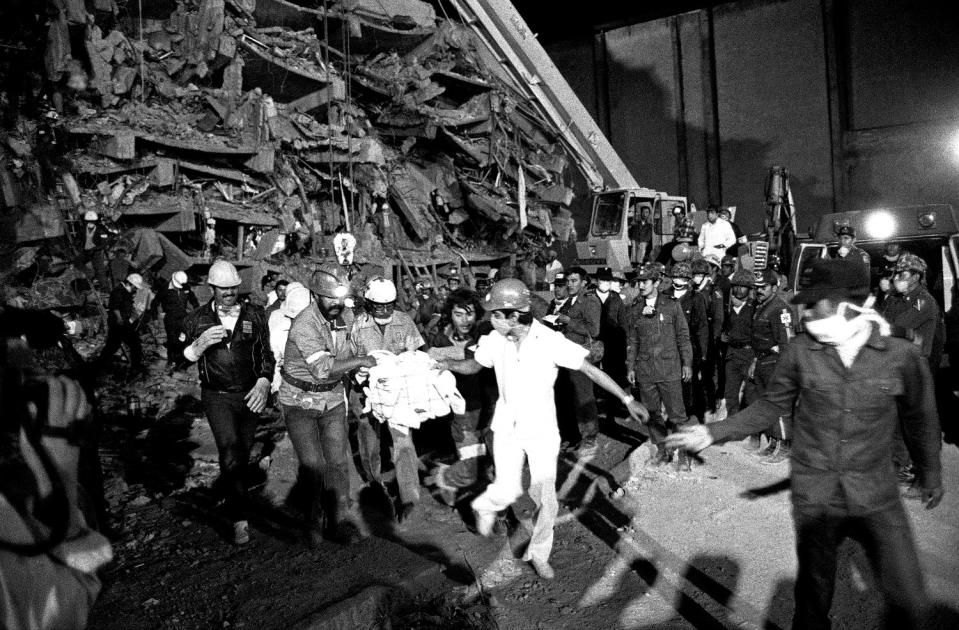 Emergency workers carry hospital patient Rubalcada Pena after rescuing him from the rubble of Mexico City's Juarez Hospital